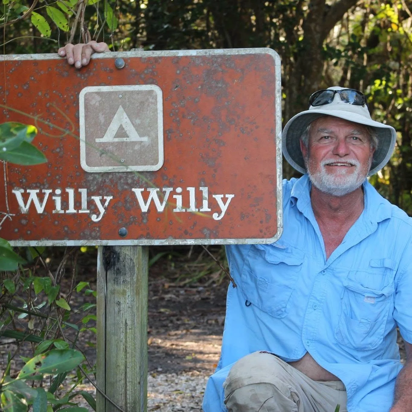 Michael Wille beside his woodshop sign